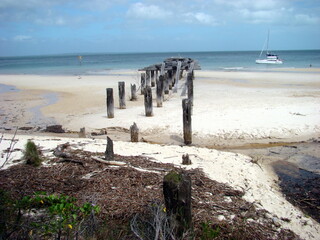old pier on the beach with boat