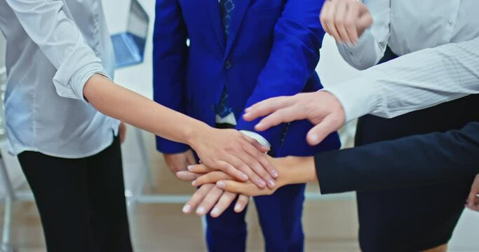 Close-up, group of businessmen stands in a circle and puts their hand on hand, team unity. Teamwork concept. 4k, ProRes