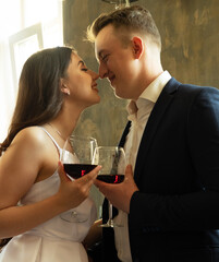 Young newlywed couple drinking wine and smiling at their happiness, romance and tenderness