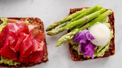 A top view of sandwiches with an egg, asparagus and ham
