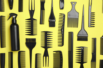 Flat lay composition with modern hair combs on yellow background