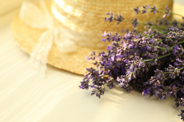 Obraz na płótnie Canvas Beautiful lavender flowers and straw hat on window sill, closeup