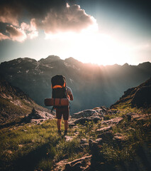 Man traveler hiking alone in breathtaking landscape of austrian Mounatins at sunset. Travel...