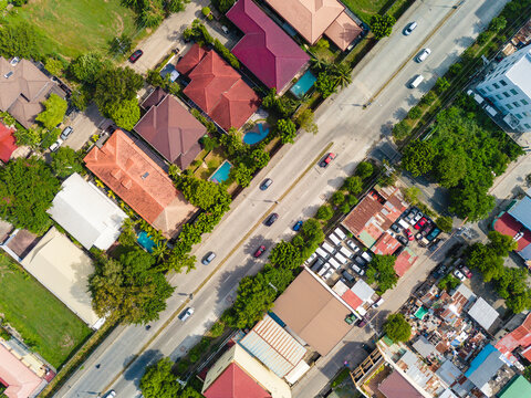 Comparison of a wealthy subdivision and a poorer area riddled with slums, separated by a wide avenue. Shot in Muntinlupa, Philippines.