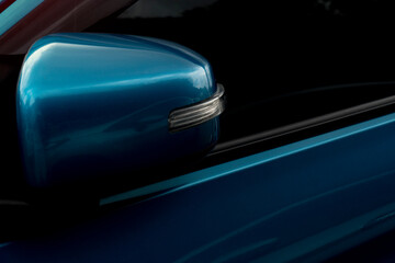 Fototapeta na wymiar Luxury of blue car side mirror that was folded down while parking.