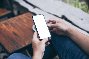 cell phone mockup blank white screen.man hand holding texting using mobile on desk at coffee shop.background empty space for advertise.work people contact marketing business,technology