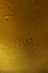 Wet glass of beer, golden color in the dark