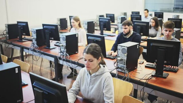 Portrait of female and male students working on computers in classroom