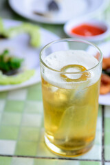 Glass of beer on dining table with natural light background.