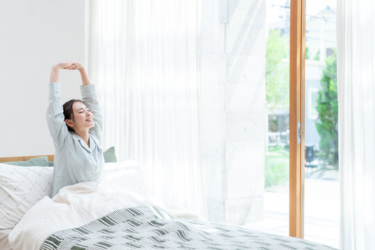 ベッドから起きる女性