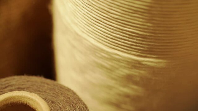 Close-up shot of yarn unwound from spinning reel. Close-up shot of unrolling thread spool.