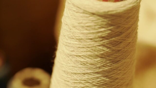 close-up shot of thread unrolled from reel. slow motion.