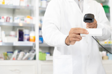 Male pharmacist scanning barcode of medicine drug to customers in modern pharmacy with Copy space