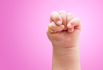 Close up infant hand with clenched fist of Trisomy 18 syndrome with gold ring on thumb