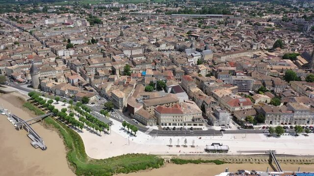 Aerial view of Libourne cityscape on banks of Dordogne river overlooking Gothic spire of Church of St. John Baptist, France