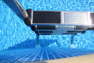 Stairs to the pool filled with clean water. Chrome plated surface.