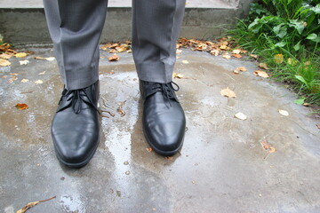 Men's legs in black boots with laces on the wet track.