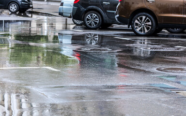 cars parked in the city street after torrential summer rain