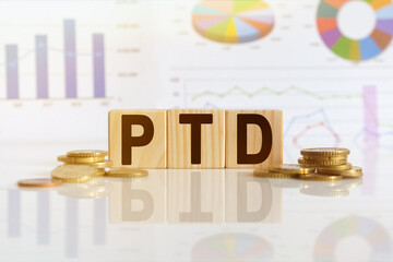 PTD the word on wooden cubes, cubes stand on a reflective surface, in the background is a business diagram.