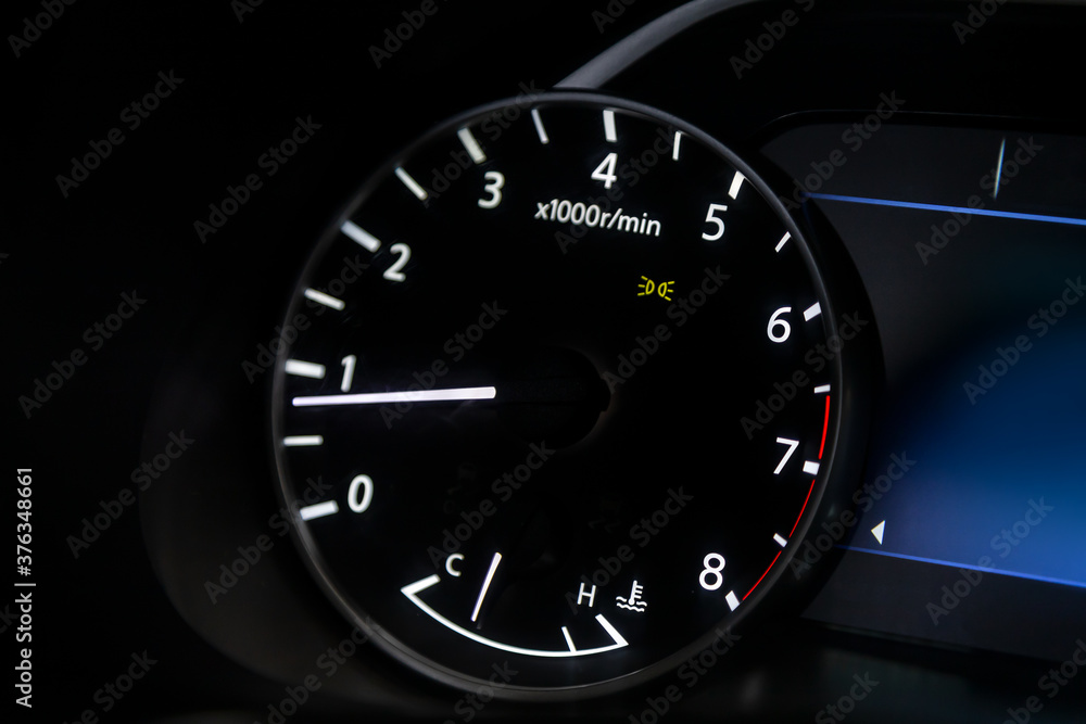 Poster dashboard of the car is illuminated by bright circle tachometer.