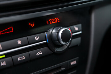 Black  detail with the air conditioning button inside a car..