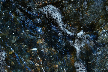 Foam on the water. Dark water.