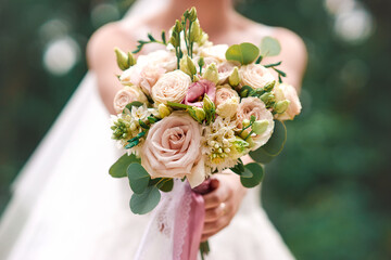 Bridal bouquet. Wedding bouquet in the hands of the bride. Outdoor shot in a sunny day.