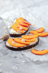 Sandwiches with cheese and nectarines on light background
