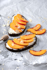 Sandwiches with cheese and nectarines on light background