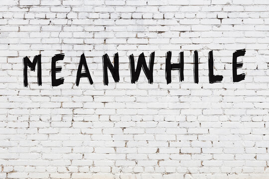 Inscription meanwhile painted on white brick wall