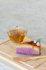 slice of homemade chiffon cake mix with Asian style dessert taro custard, can see layer and topping by fried onion served with tea on wooden board