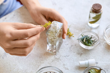 Woman making natural air freshener at table, closeup