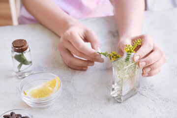 Woman making natural air freshener at table