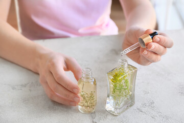 Woman making natural air freshener at table, closeup