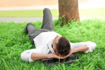 Handsome businessman relaxing in park