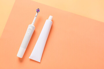 Electric tooth brush and paste on color background