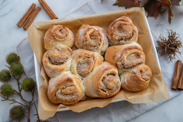Cinnamon rolls with sugar frosting. With cinnamon sticks and spices, wooden background
