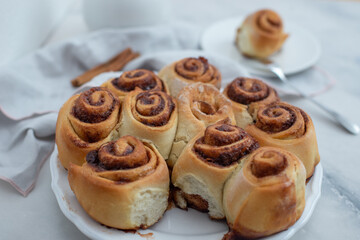 Cinnamon rolls with sugar frosting. With cinnamon sticks and spices, wooden background