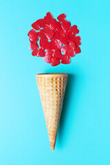 Waffle horn and red hearts on blue background, vertical orientation