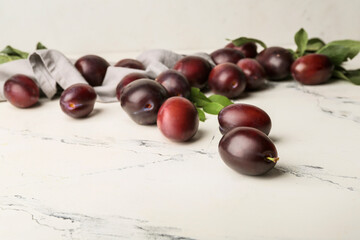 Tasty sweet plums on white background