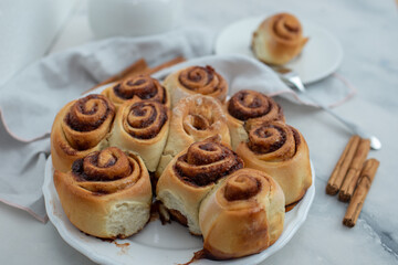 Cinnamon rolls with sugar frosting. With cinnamon sticks and spices, wooden background
