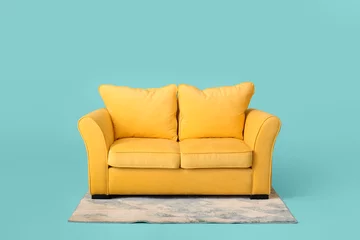 Foto op Plexiglas Stylish sofa and carpet on color background © Pixel-Shot