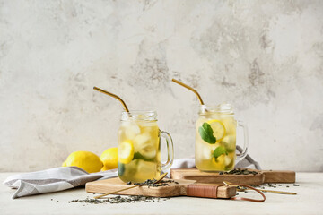 Mason jars of tasty cold ice tea on table