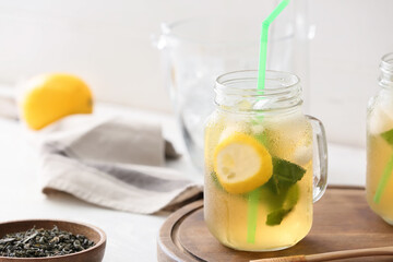 Mason jar of tasty cold ice tea on table