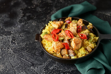 Frying pan with tasty rice on dark background