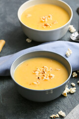 Bowls with tasty popcorn soup on dark background