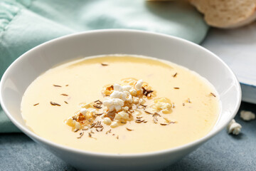 Bowl with tasty popcorn soup on table, closeup