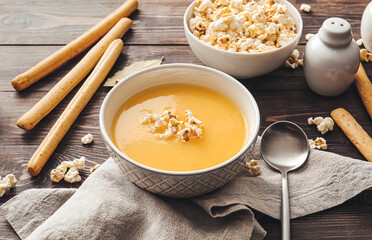 Bowl with tasty popcorn soup on table