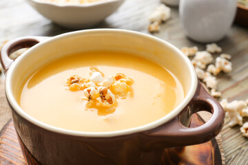 Pot with tasty popcorn soup on table, closeup