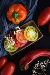 Tragetasche Rijpe tomaten op een zwarte achtergrond.Heerlijk vegetarisch eten. © NADEZHDA